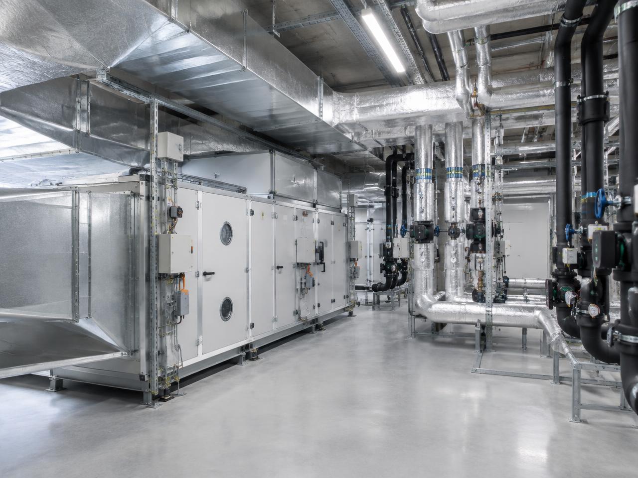 Modern HVAC plant room with ventilation equipment and coordinated insulated pipework